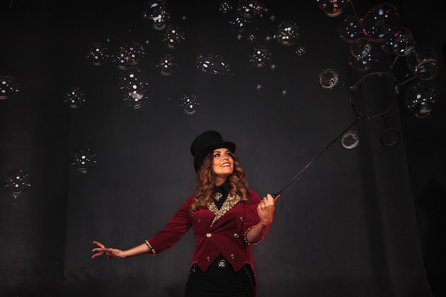 Female magician makes with soap bubbles show an illusionist