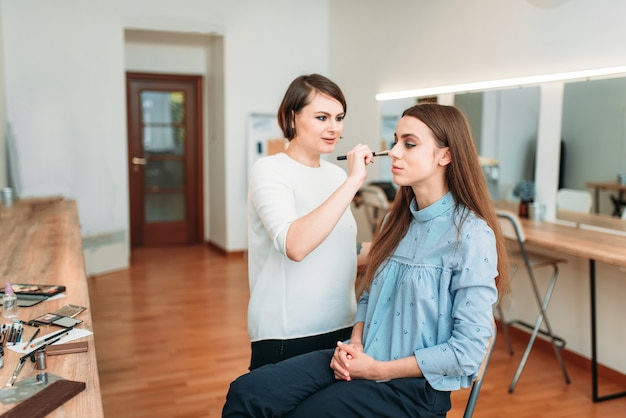 Female make up artist work with woman face