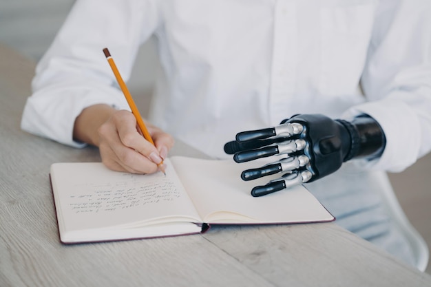 Female makes notes writes in diary holds notebook using robotic hand Bionic prosthesis advertising