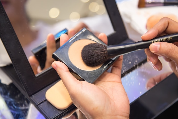 Female makeup artist with cosmetics at work close-up