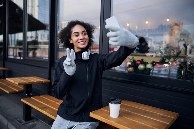 Female making selfie while showing two fingers