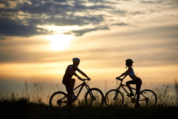 Female and male cyclist riding the bike into the mountains