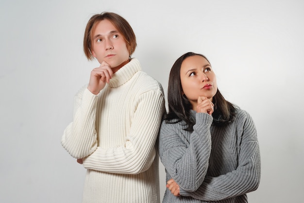 Female and male standing near each other having pensive expressions trying to find solution.