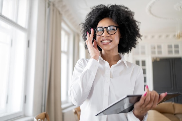 A female manager in computer glasses works in an office\
coworking space in formal clothes