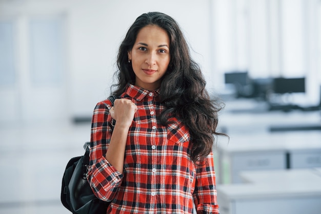 Photo female manager is ready to work. portrait of attractive young woman standing in the office with black bag.