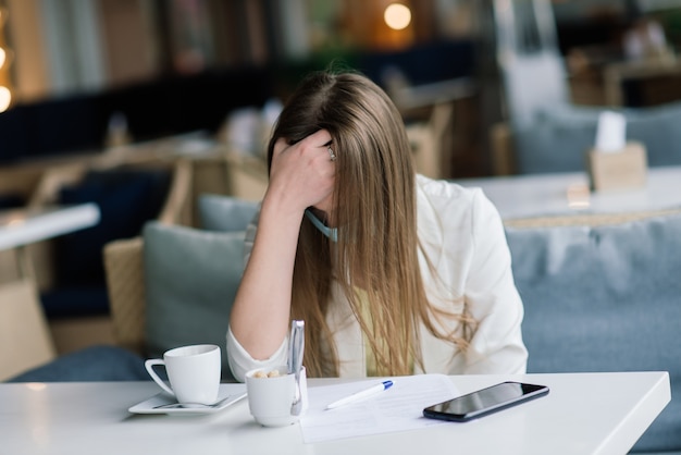 Responsabile femminile in un vestito e una maschera medica lavora a distanza su street cafe