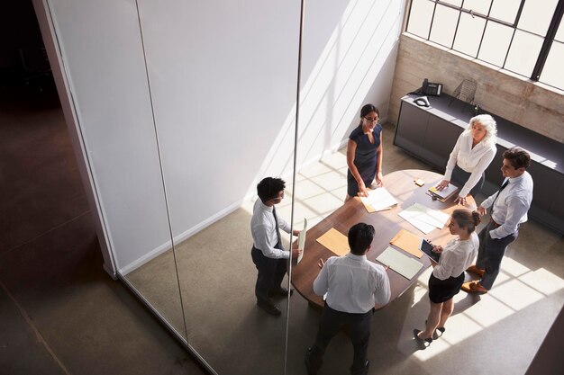 Female manager in team meeting elevated view through window