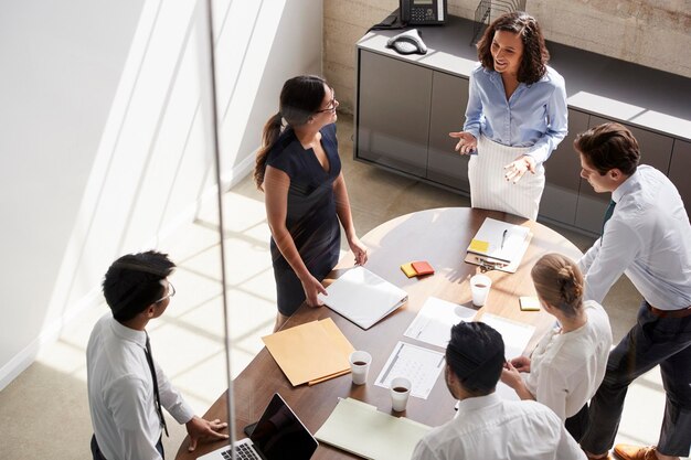 Female manager in team meeting elevated view through window