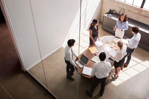 Female manager in team meeting elevated view through window