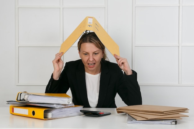 Female manager with document folder on head holding hand to heart