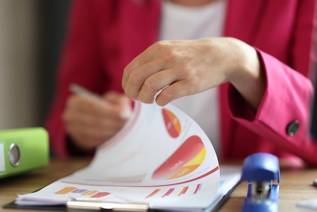 Female manager working with financial document on clipboard in office business woman correcting