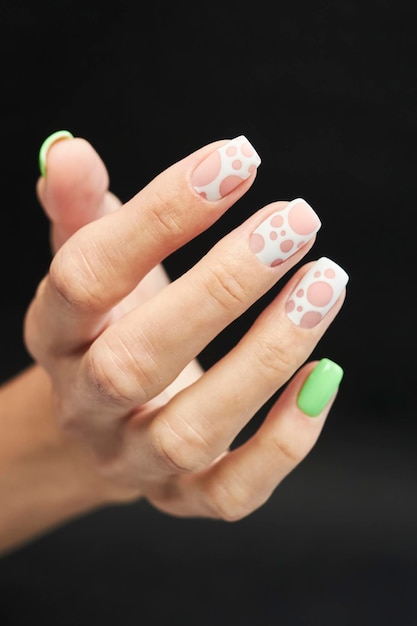 female manicure on a black background. nail. Women's hands with a manicure on a dark background.