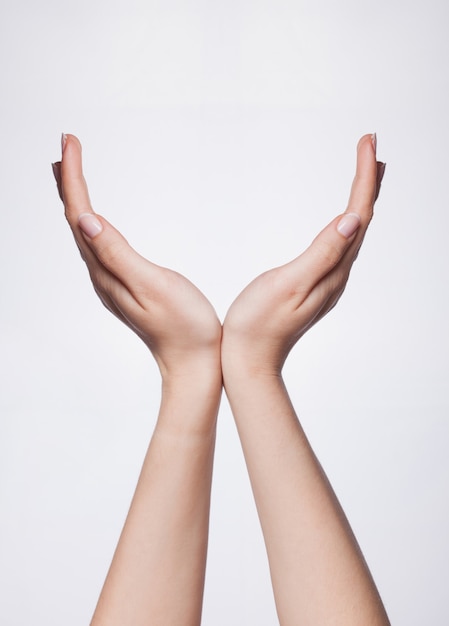 Female manicured hand measuring invisible items, woman's palm making gesture