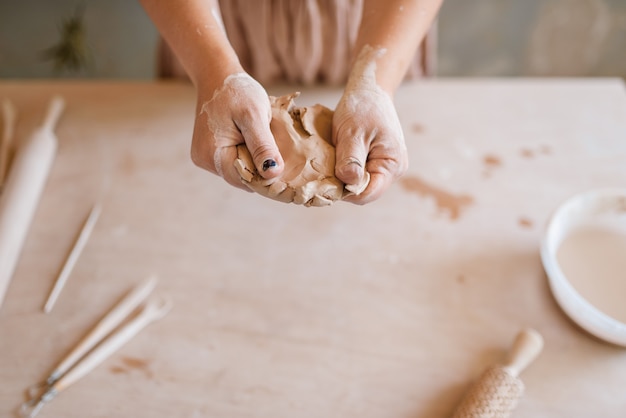 Female master shaping clay, pottery workshop