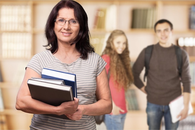 Female mature teacher with books and  students