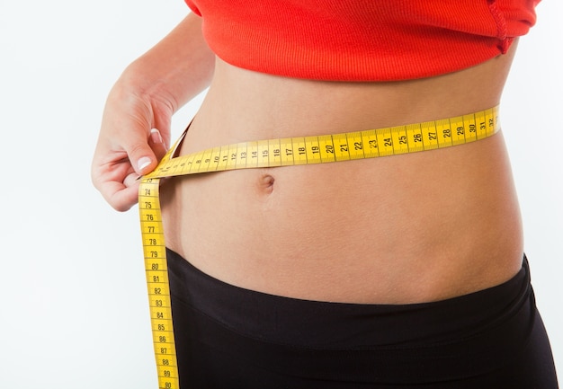 Female measuring her waist with tape-line