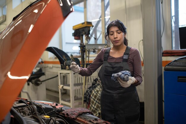 Female Mechanic Measuring Oil Level