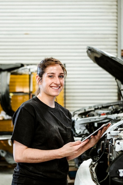 Female mechanic running a diagnostic on a car engine