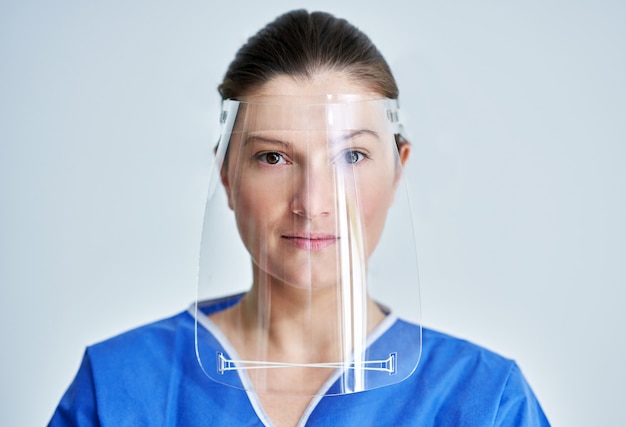 Photo female medical doctor or nurse wearing protective face shield