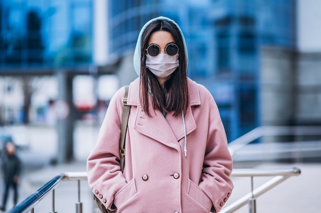 Photo female in medical mask outdoors in the empty city. health protection and prevention of virus outbreak, coronavirus, covid-19, epidemic, pandemic, infectious diseases, quarantine concept.
