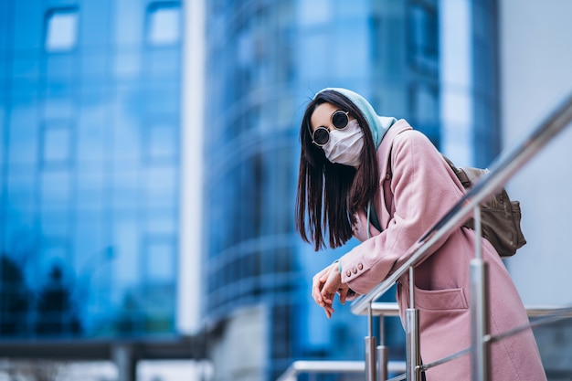 Female in medical mask outdoors in the empty city. Health protection and prevention of virus outbreak, coronavirus, COVID-19, epidemic, pandemic, infectious diseases, quarantine concept.