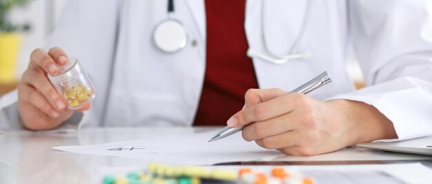 Female medicine doctor fills up prescription form to patient\
closeup. panacea and life save, prescribe treatment, legal drug\
store, contraception concept