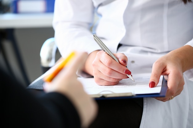 Il barattolo femminile della tenuta della mano di medico della medicina delle pillole e scrive la prescrizione al paziente al worktable. panacea e salvavita prescrivono il concetto legale di farmacia. modulo vuoto pronto per essere utilizzato