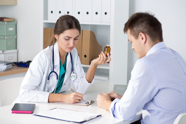 Female medicine doctor prescribing pills to patient