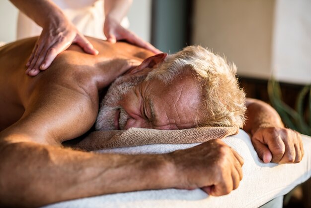 Foto terapeuta del messaggio femminile che dà un massaggio ad una stazione termale