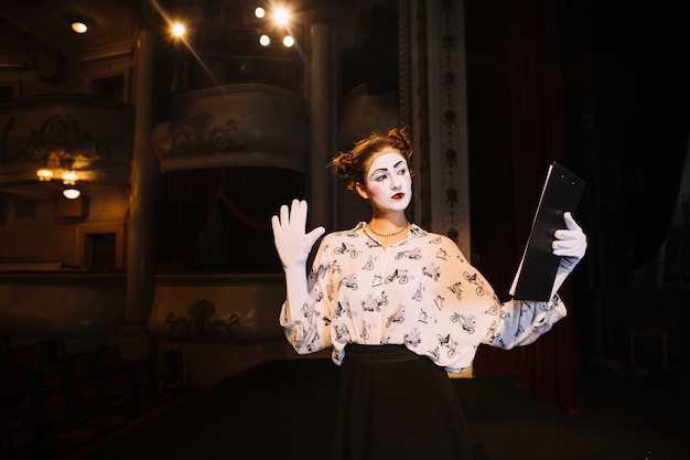 female mime holding script rehearsing on stage