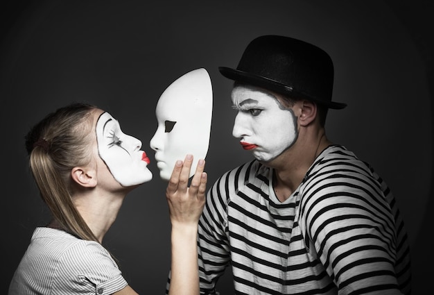 Photo female mime kissing the mask of male mime