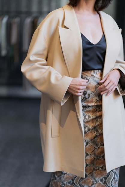 A female model posing shows off a new beige coat A fashionable women's clothing store