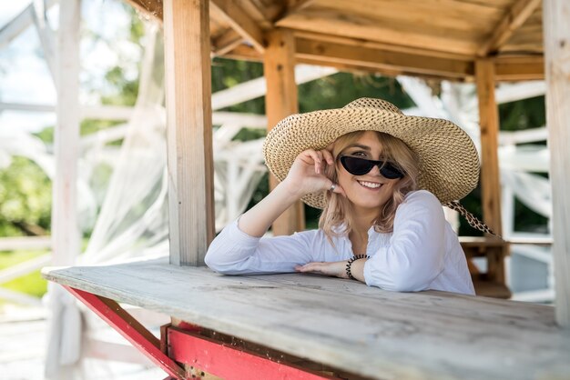 Female model posing in wooden gazebo near lake ar sity park. summer lifestyle day