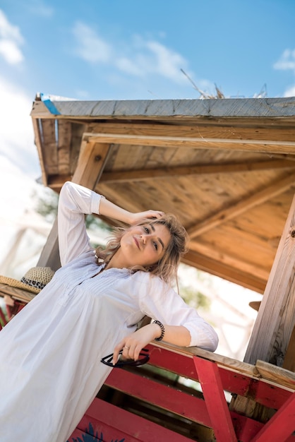 Female model posing in wooden gazebo near lake ar sity park. summer lifestyle day