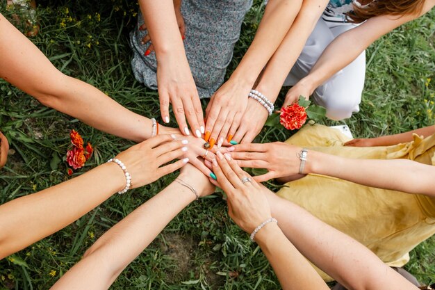female models joining hands in a circle teamwork