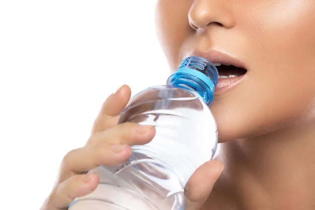 Foto bocca femminile e bottiglia d'acqua