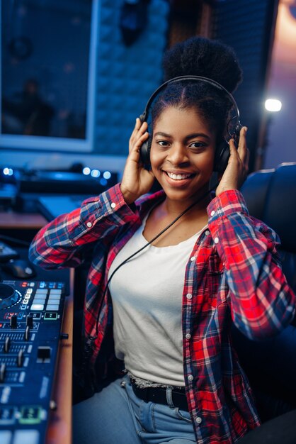 Female musician in headphones in recording studio