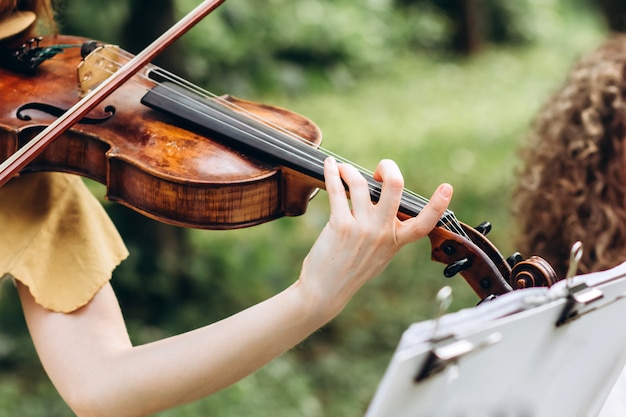 Female musician performs at an outdoor wedding.