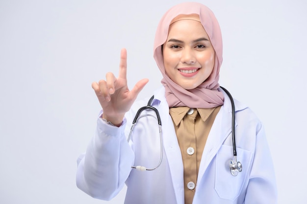 Женщина-врач-мусульманка с хиджабом на белом фоне студии.