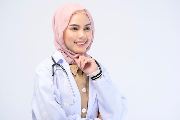 白い背景のスタジオにヒジャーブを持つ女性のイスラム教徒の医師