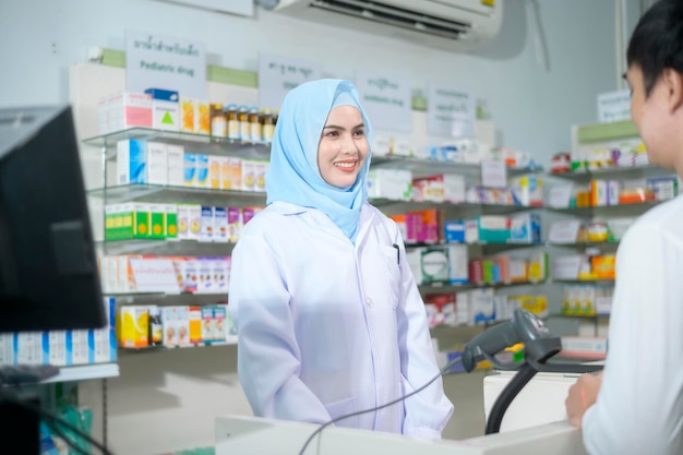 Female muslim pharmacist counseling customer about drugs usage in a modern pharmacy drugstore