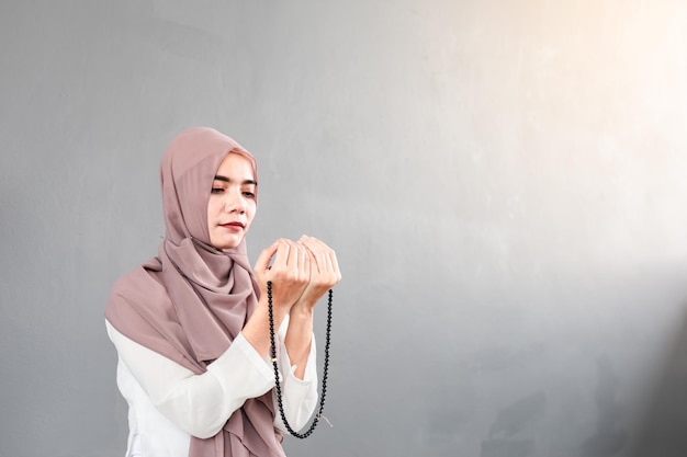 Foto donna musulmana che prega con le mani aperte