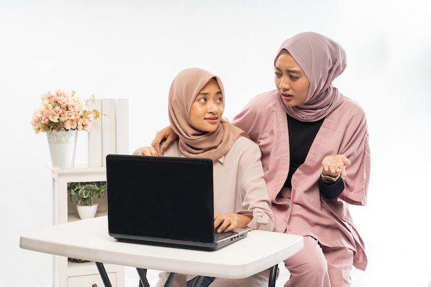 Female muslim with hijab working on their laptop together