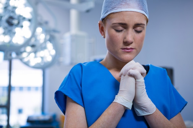 Infermiera femminile che prega teatro in funzione