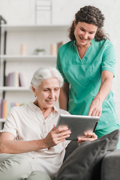 Foto infermiera femminile con il suo paziente guardando video su tavoletta digitale