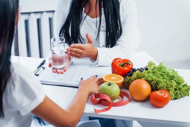 Female nutritionist gives consultation to patient indoors in the office.