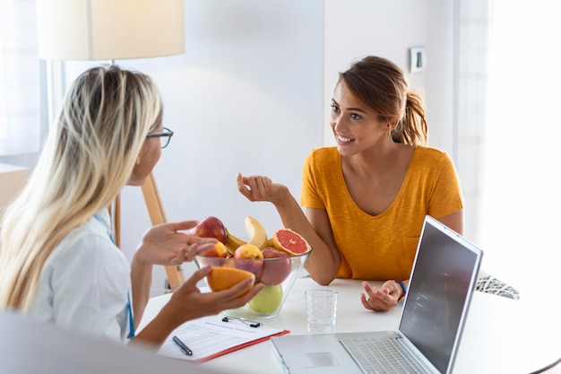 Foto nutrizionista femminile che dà consulenza al paziente fare un programma di dieta nella clinica di perdita di peso