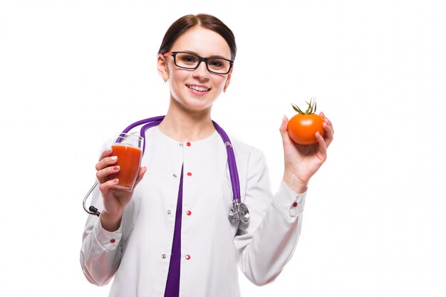 Female nutritionist hold tomato in section and glass of juice in her hands on white 