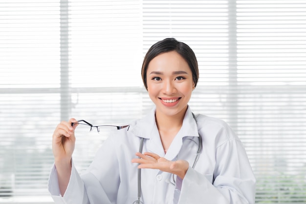 Female oculist giving a pair of eyeglasses