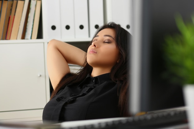 Женщина-офисная работница во время перерыва вздремнула с закрытыми глазами на работе